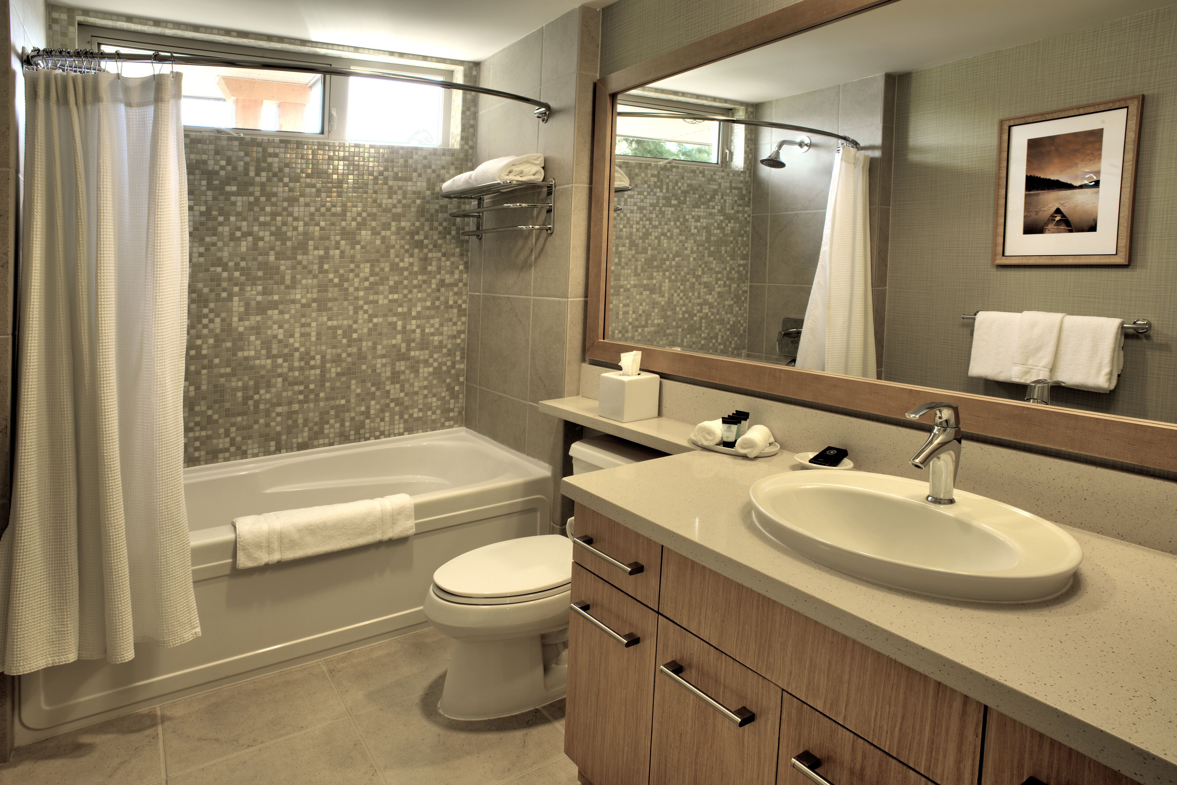 A modern bathroom with a bathtub, toilet, and sink.