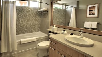 A modern bathroom with a bathtub, toilet, and sink.