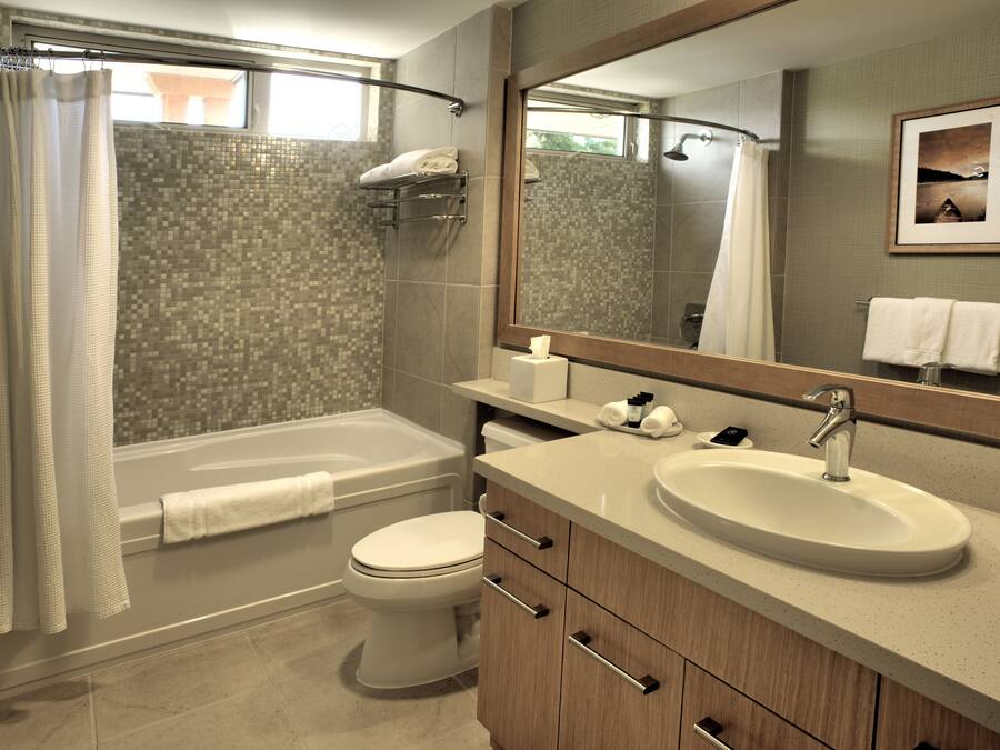 A modern bathroom with a bathtub, toilet, and sink.