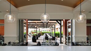 Un restaurant doté d’une grande salle à manger, de nombreuses tables et de luminaires sphériques suspendus au plafond.