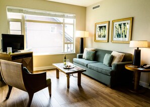 A living room with a sofa, a coffee table, a TV, and a lamp.