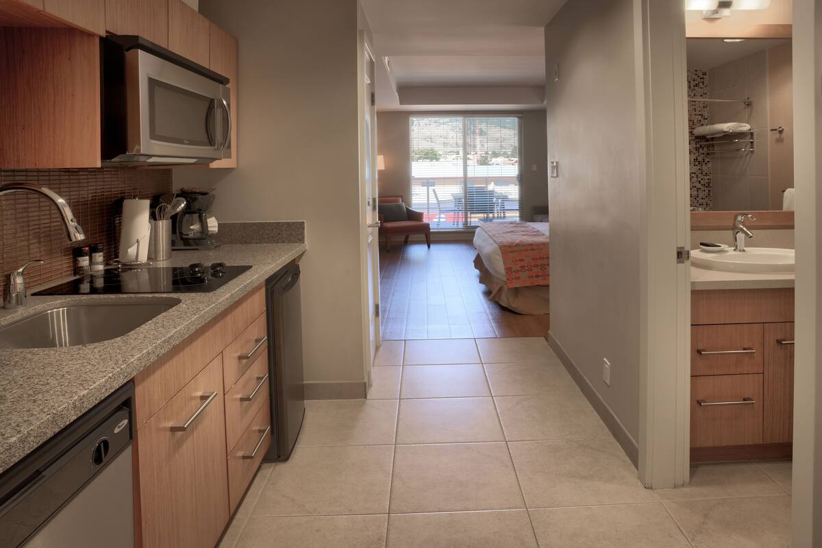 A modern kitchen with granite countertops, stainless steel appliances, and wooden cabinets.