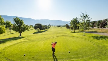 Golfers can enjoy a round on the well-maintained course with lush green grass and scenic views of the surrounding mountains.