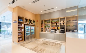A self-service kiosk with refrigerated drinks, snacks, and a coffee machine. - Hilton Garden Inn Kuala Lumpur Jalan Tuanku Abdul Rahman North (Kuala Lumpur)
