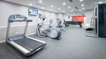 A gym with treadmills, elliptical machines, and free weights.