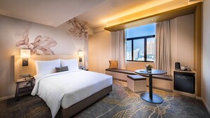 A hotel room with a large bed, bedside lamps, a desk, a small table, and a view of the city. - Hilton Garden Inn Kuala Lumpur Jalan Tuanku Abdul Rahman North (Kuala Lumpur)