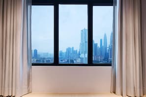 A window with a view of a cityscape, curtains, and a plain wall. - Hilton Garden Inn Kuala Lumpur Jalan Tuanku Abdul Rahman North (Kuala Lumpur)