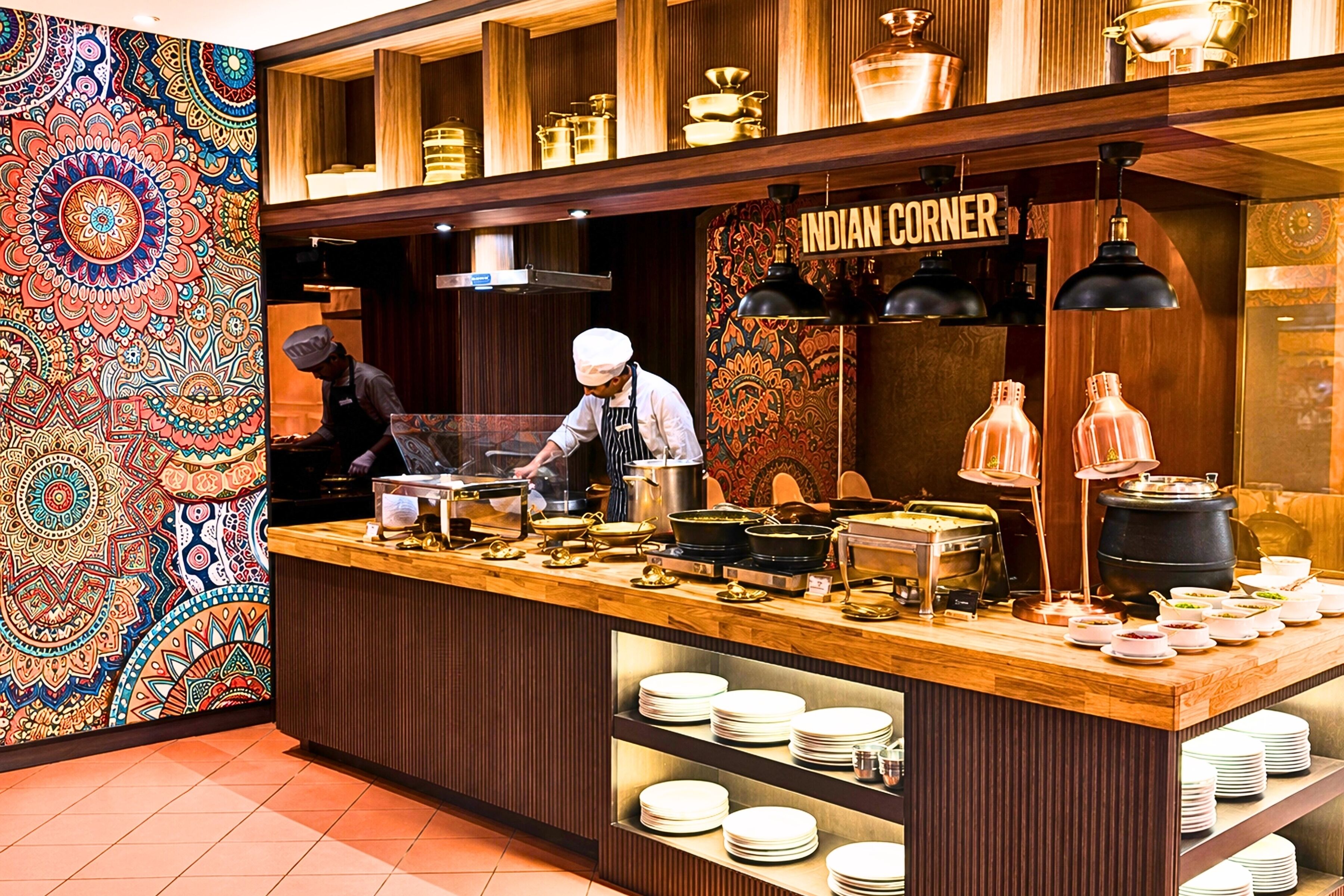 A buffet counter with a variety of dishes and a sign that reads 'INDIAN CORNER'.