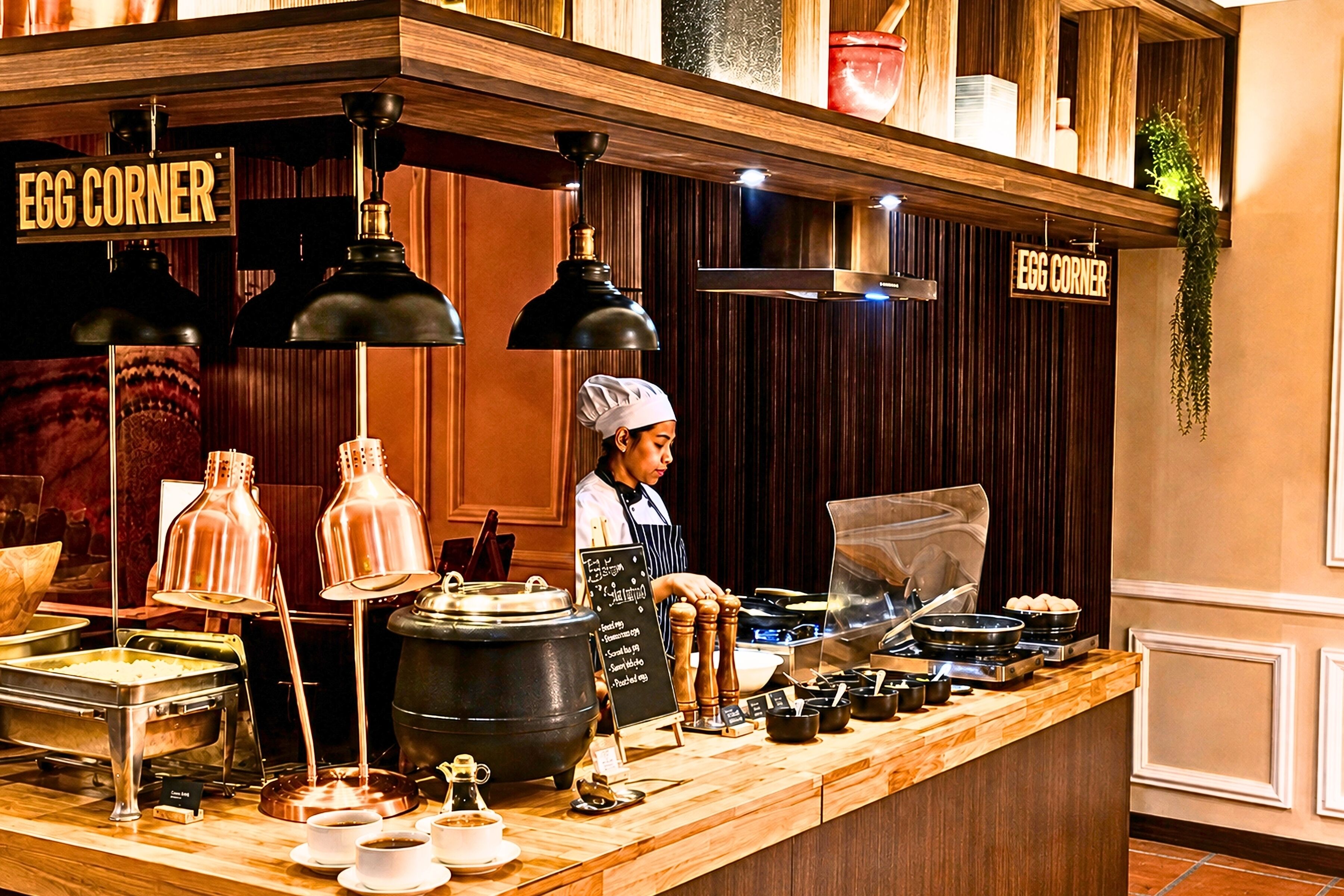 A buffet setup with a chef, a sign reading 'EGG CORNER', and various food items displayed.