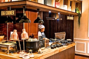A buffet setup with a chef, a sign reading 'EGG CORNER', and various food items displayed. - Howard Johnson By Wyndham Kuala Lumpur 118 (Kuala Lumpur)
