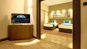 A hotel room with a bed, a TV, and a mirror. - Howard Johnson By Wyndham Kuala Lumpur 118 (Kuala Lumpur)