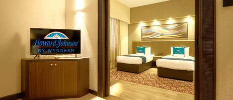 Una habitación de hotel con una cama, un televisor y un espejo.