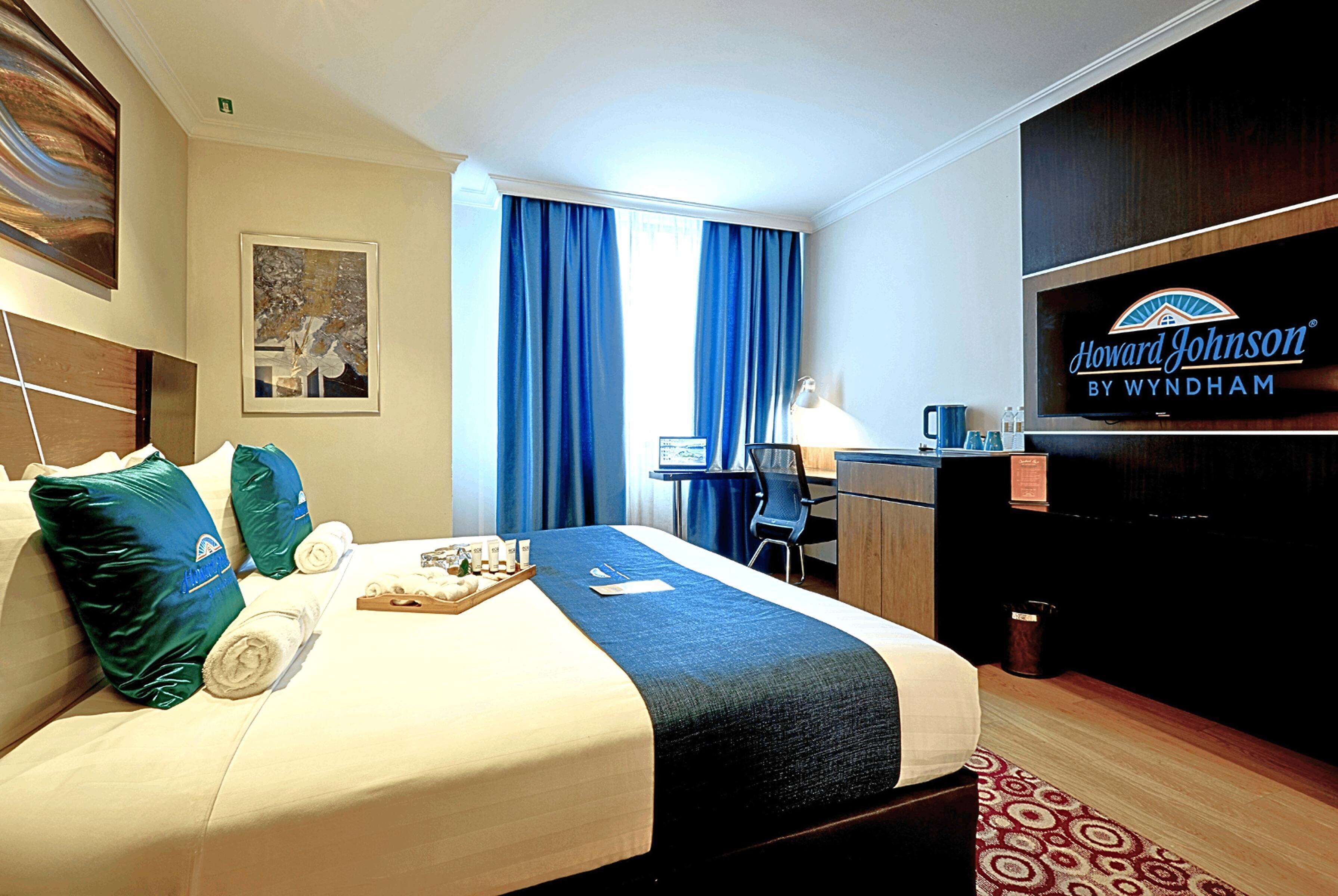 Ein Hotelzimmer mit Bett, Schreibtisch und Fernseher.