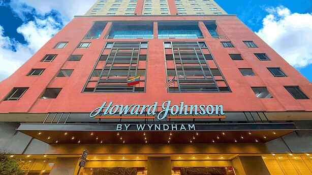 The exterior of the Howard Johnson by Wyndham hotel with a prominent sign, large windows, and a red facade. - Howard Johnson By Wyndham Kuala Lumpur 118 (Kuala Lumpur)