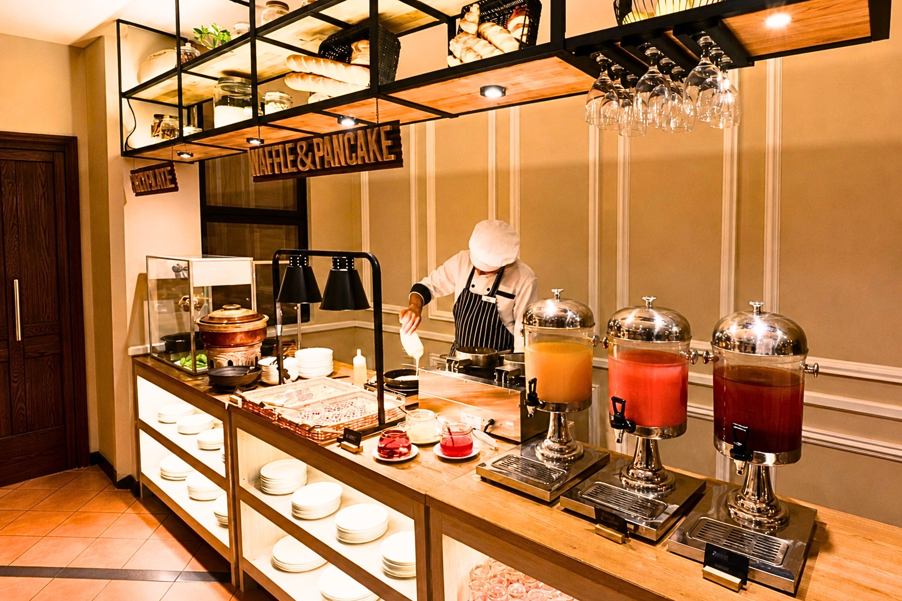 Zona de bufé con diversas opciones de comida y dispensadores de bebidas.
