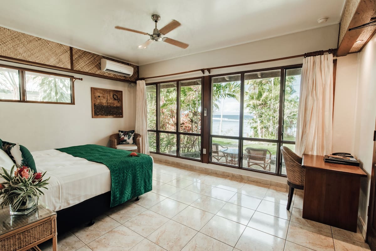 Una habitación amplia con cama, escritorio y vistas al exterior.