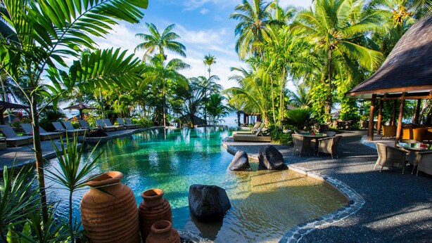 A tropical resort with a swimming pool, lounge chairs, and palm trees. - Sinalei Reef Resort & Spa (Siumu)