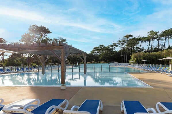 Piscine extérieure en saison, parasols, chaises longues