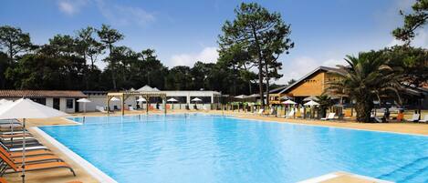 Una piscina al aire libre de temporada, sombrillas