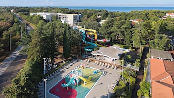 Een waterpark met een grote glijbaan, zwembad en veel groen.