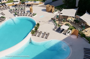 Una piscina techada, una piscina al aire libre, sombrillas