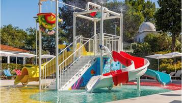 Una piscina cubierta, una piscina al aire libre, sombrillas