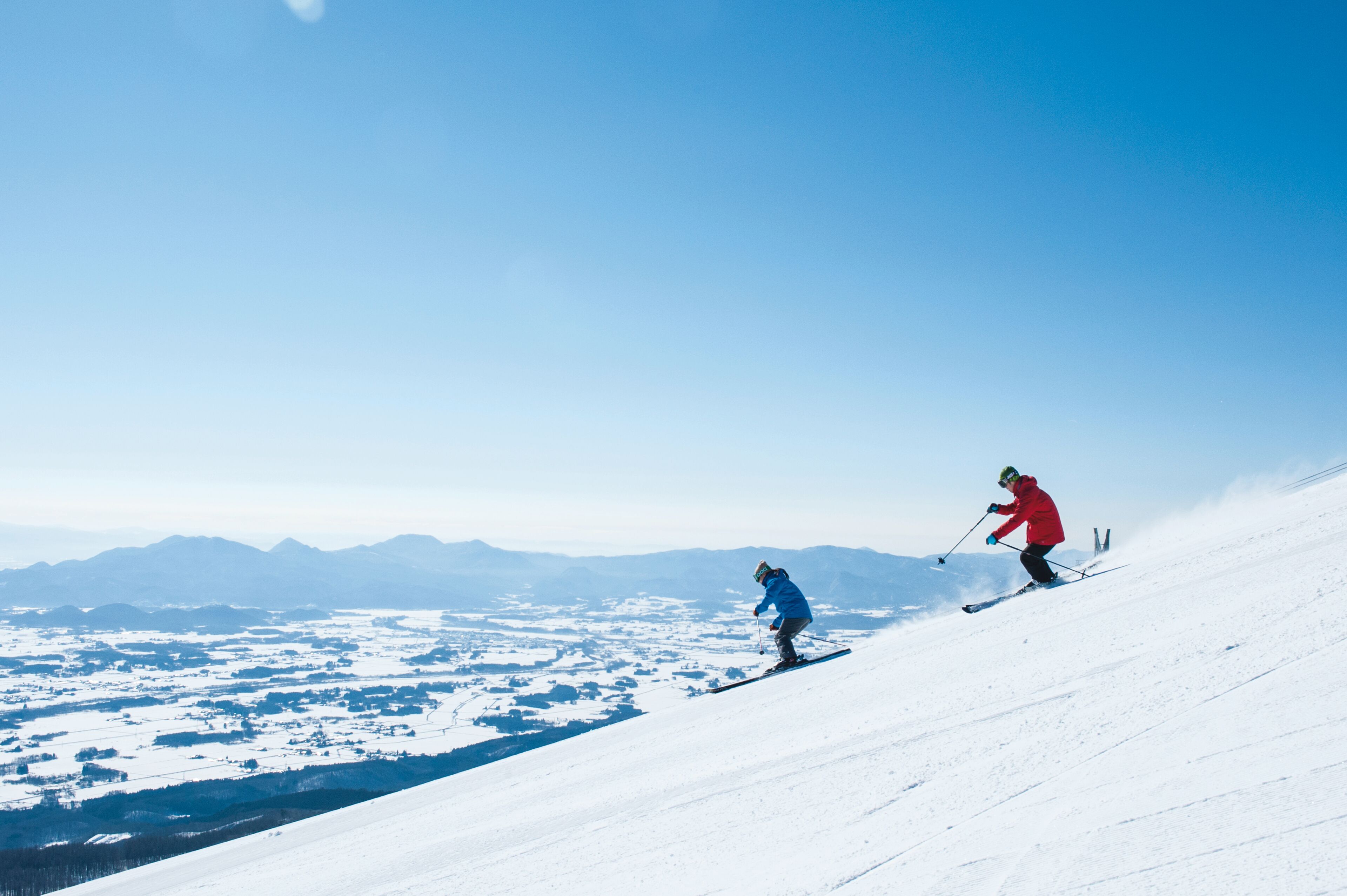 Ein verschneiter Ski-Hang mit Skifahrern.