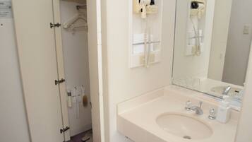 A bathroom with a sink, mirror, and hairdryer.