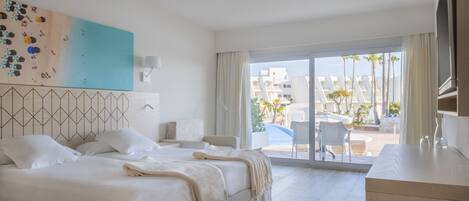 Habitación de hotel con una cama grande, un escritorio y vistas al exterior.