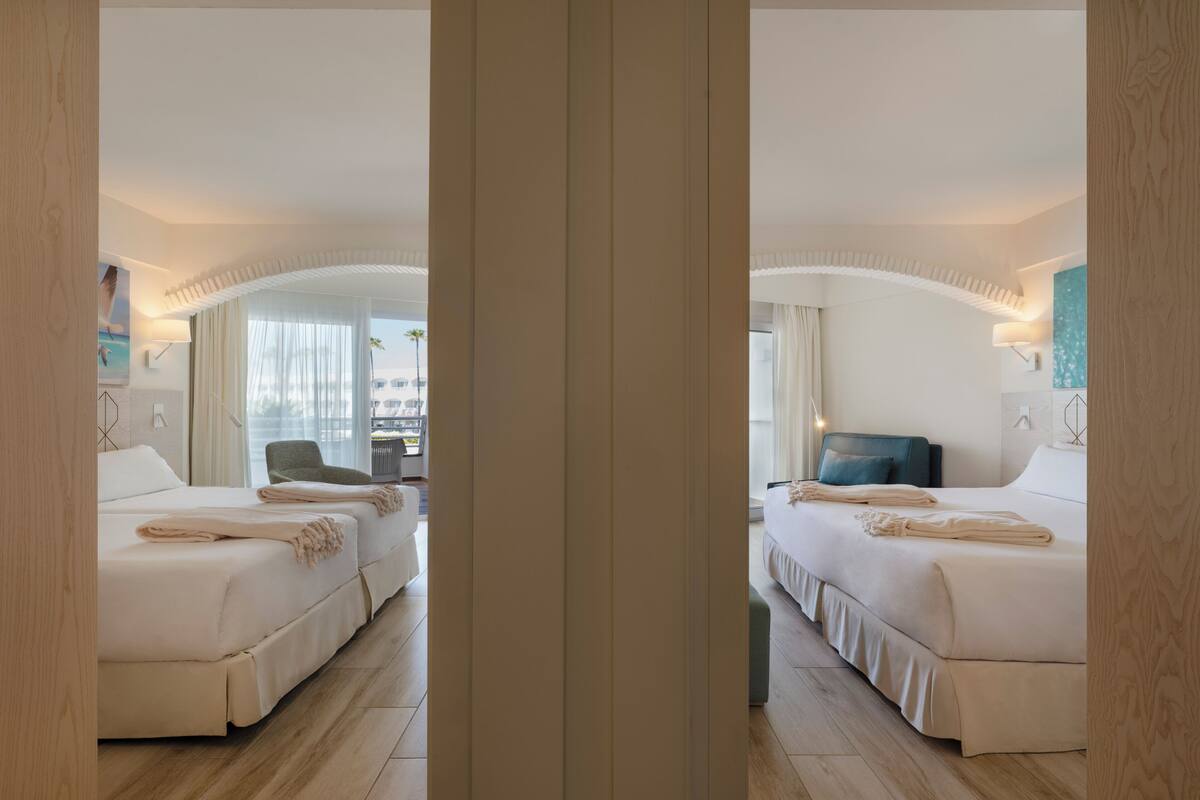 Een hotelkamer met twee bedden, een bureau en een stoel.