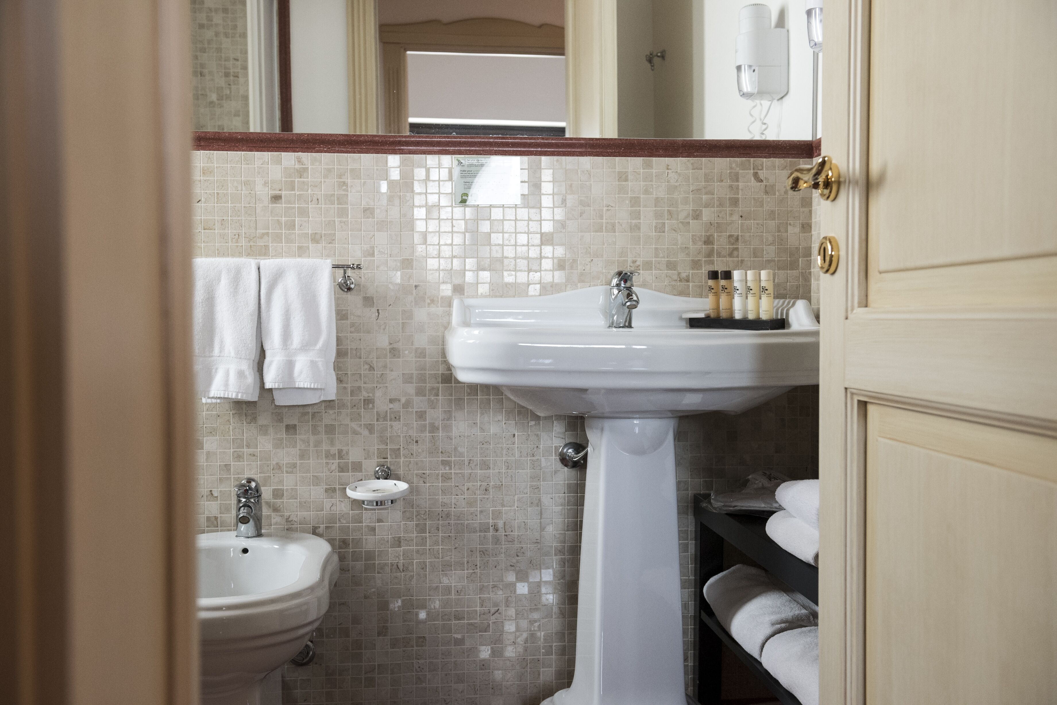 A bathroom with a sink, mirror, and towel rack.