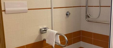 A bathroom with a shower, toilet, and a towel rack.