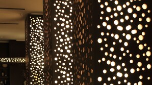 Un pasillo con paredes decoradas con lámparas circulares, creando un diseño de puntos iluminados.