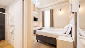 A modern hotel room with a large bed, a bedside table, a TV, and a chandelier. - Hotel Bijou Roof Terrace (Florence)