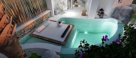 A modern spa area with a large, curved hot tub, a hanging chair, and a stone wall with vertical elements.