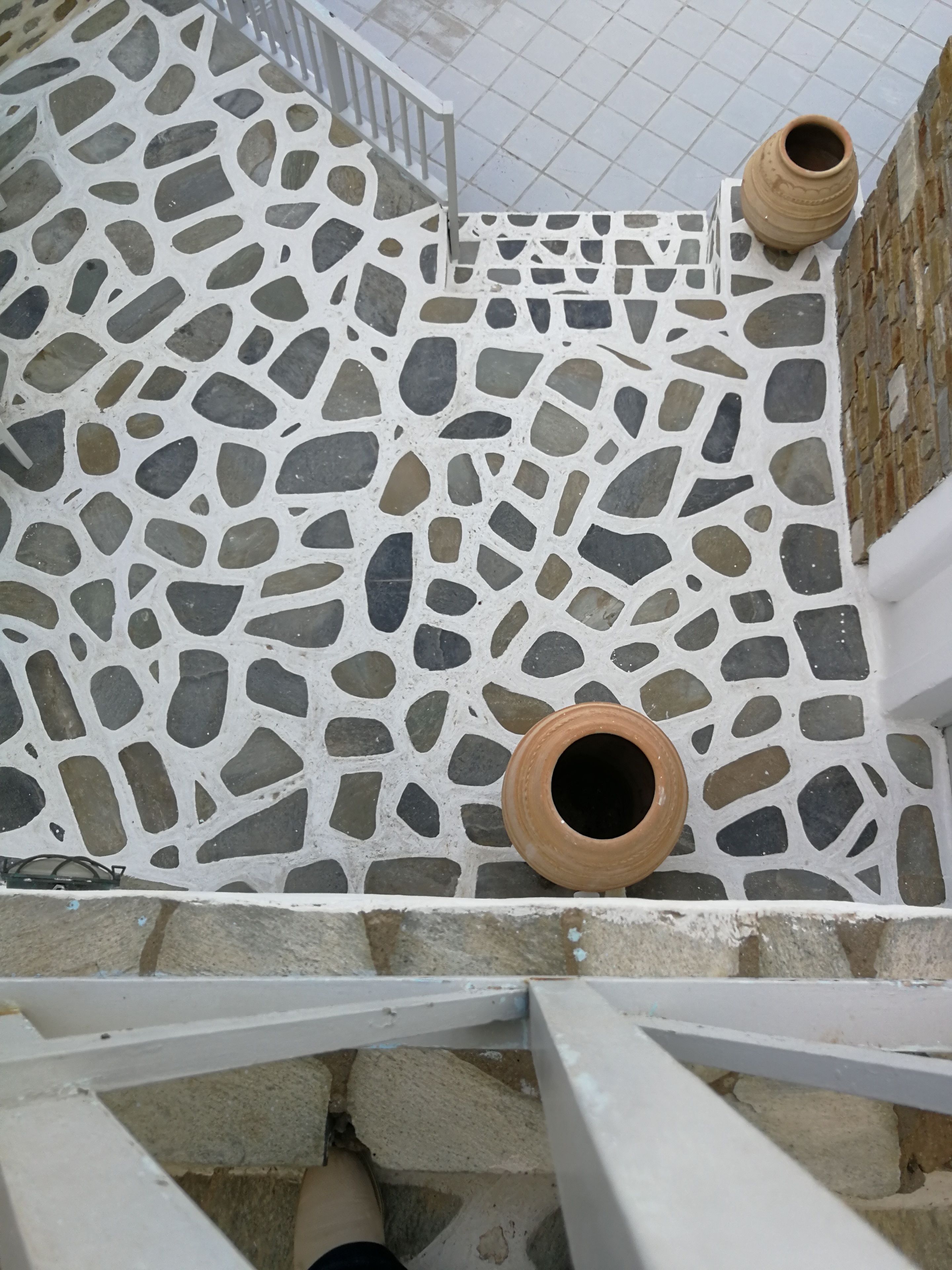 Un escalier avec un sol en terrazzo et des rampes blanches.
