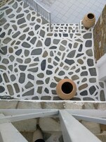 Een trap met een terrazzovloer en witte leuningen.