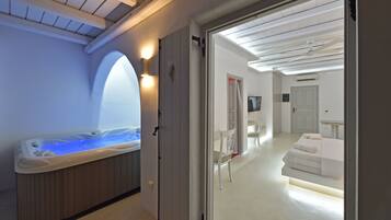 Une salle de spa équipée d’un bain à remous, d’une table de massage et d’un espace douche.