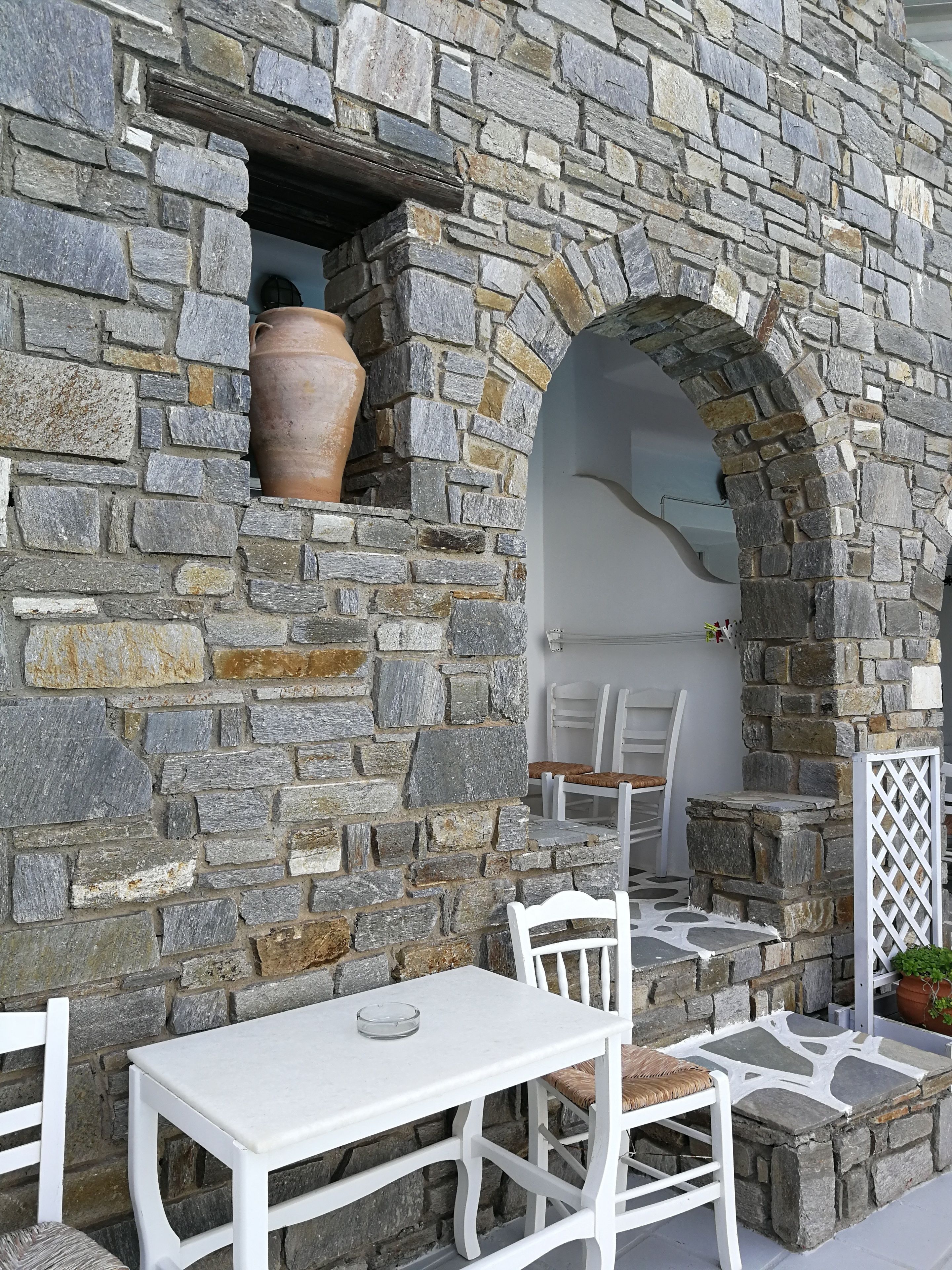 A stone wall with a built-in seating area, including a table and chairs.