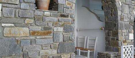 A stone wall with a built-in seating area, including a table and chairs.