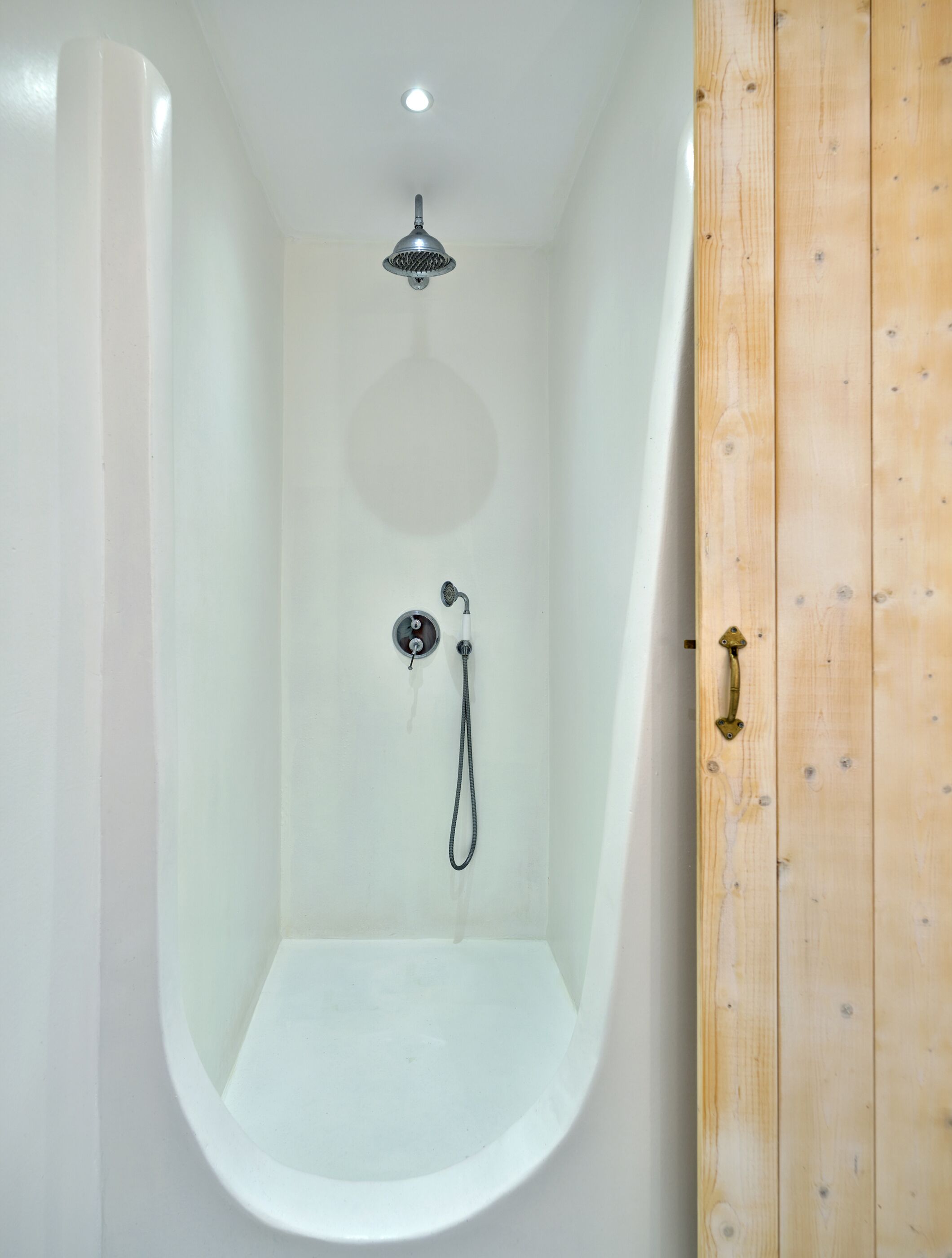 A modern, empty bathtub with a showerhead and faucet.