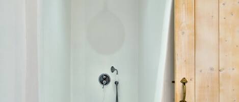 A modern, empty bathtub with a showerhead and faucet.