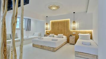 A modern hotel room with two beds, a large window, and a ceiling light fixture.