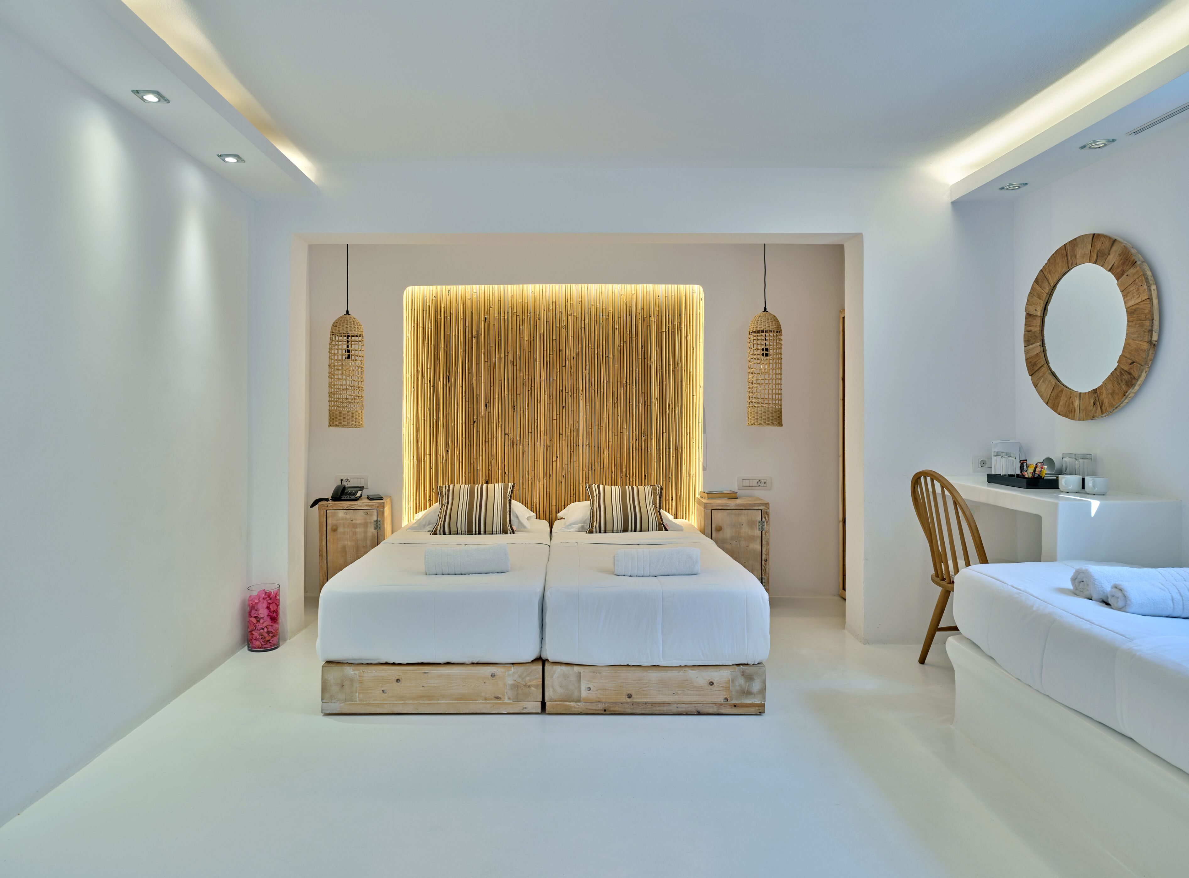 Un dormitorio moderno con una cama grande, mesitas de noche, un escritorio y un espejo.