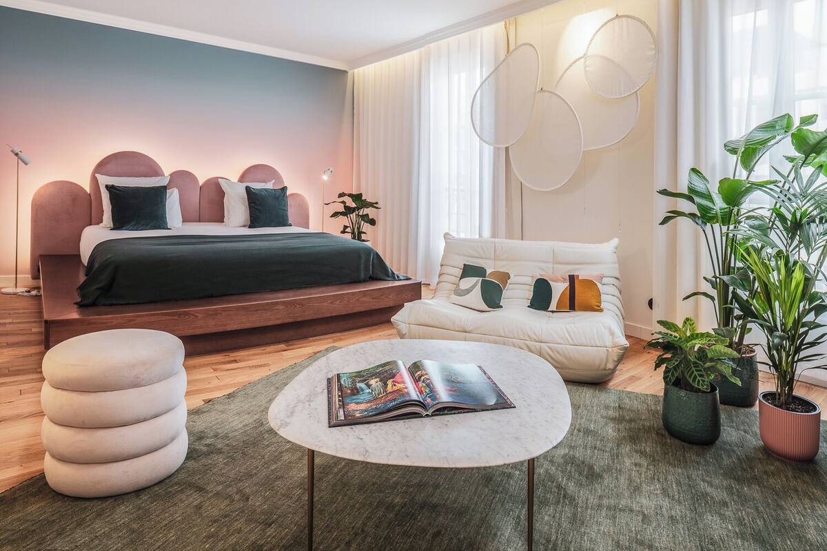 A modern bedroom with a bed, bedside table, and a sofa.