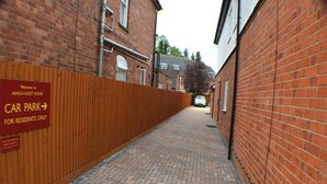 A narrow brick alley with a sign indicating a car park for residents. - Ashlea Guest House (Banbury)