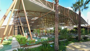 A covered outdoor area with a metal framework, seating, and greenery. - Salinas Maragogi All Inclusive Resort (Maragogi)