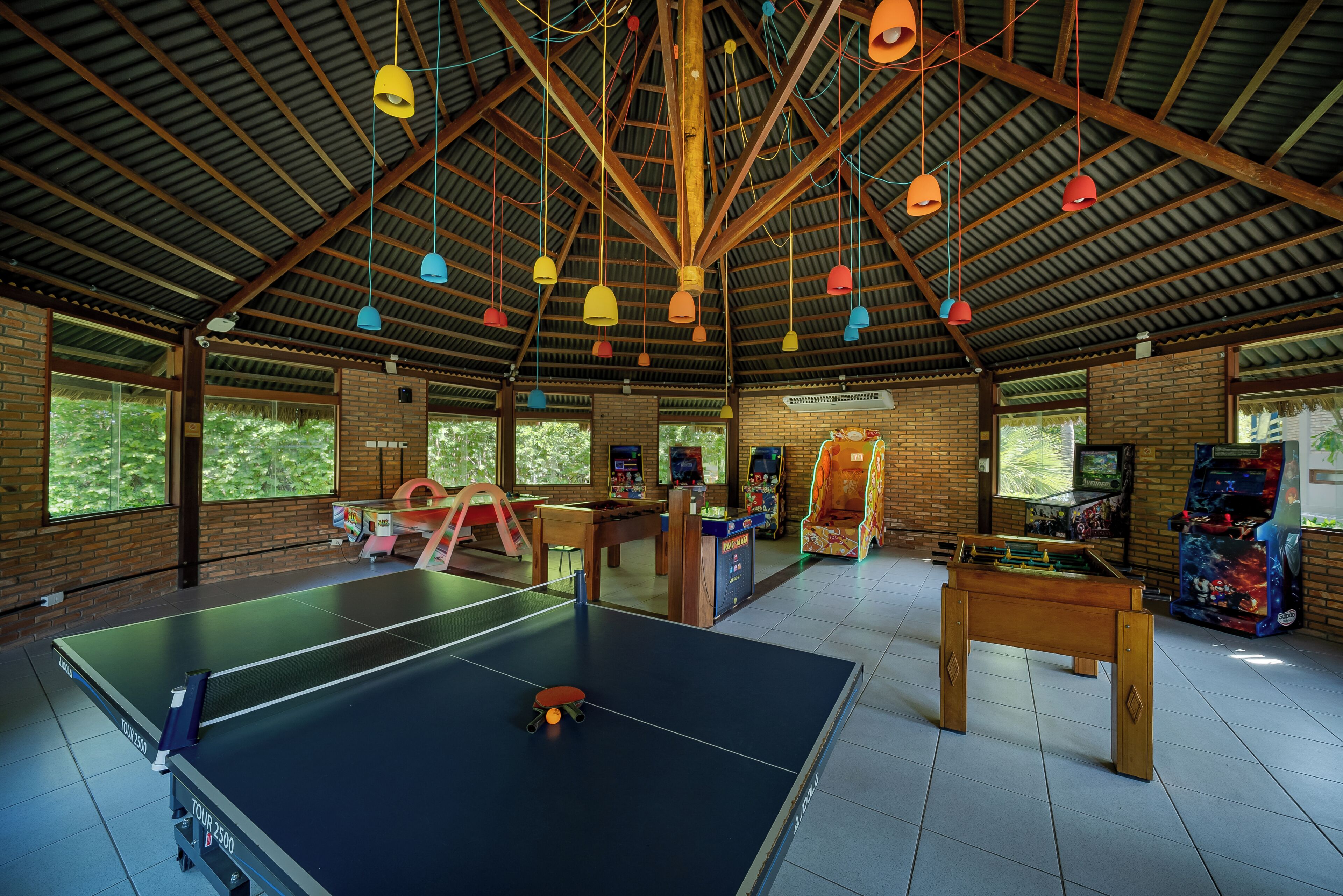 A spacious indoor area with a ping pong table, a foosball table, and arcade games.