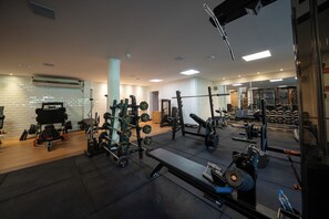 A gym with various exercise equipment, a bench, and a mirrored wall. - Salinas Maragogi All Inclusive Resort (Maragogi)