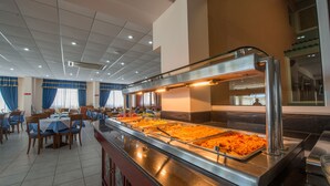 A buffet area with multiple serving stations, tables, and chairs arranged for dining. - Hotel Astir Palace (Zakynthos)